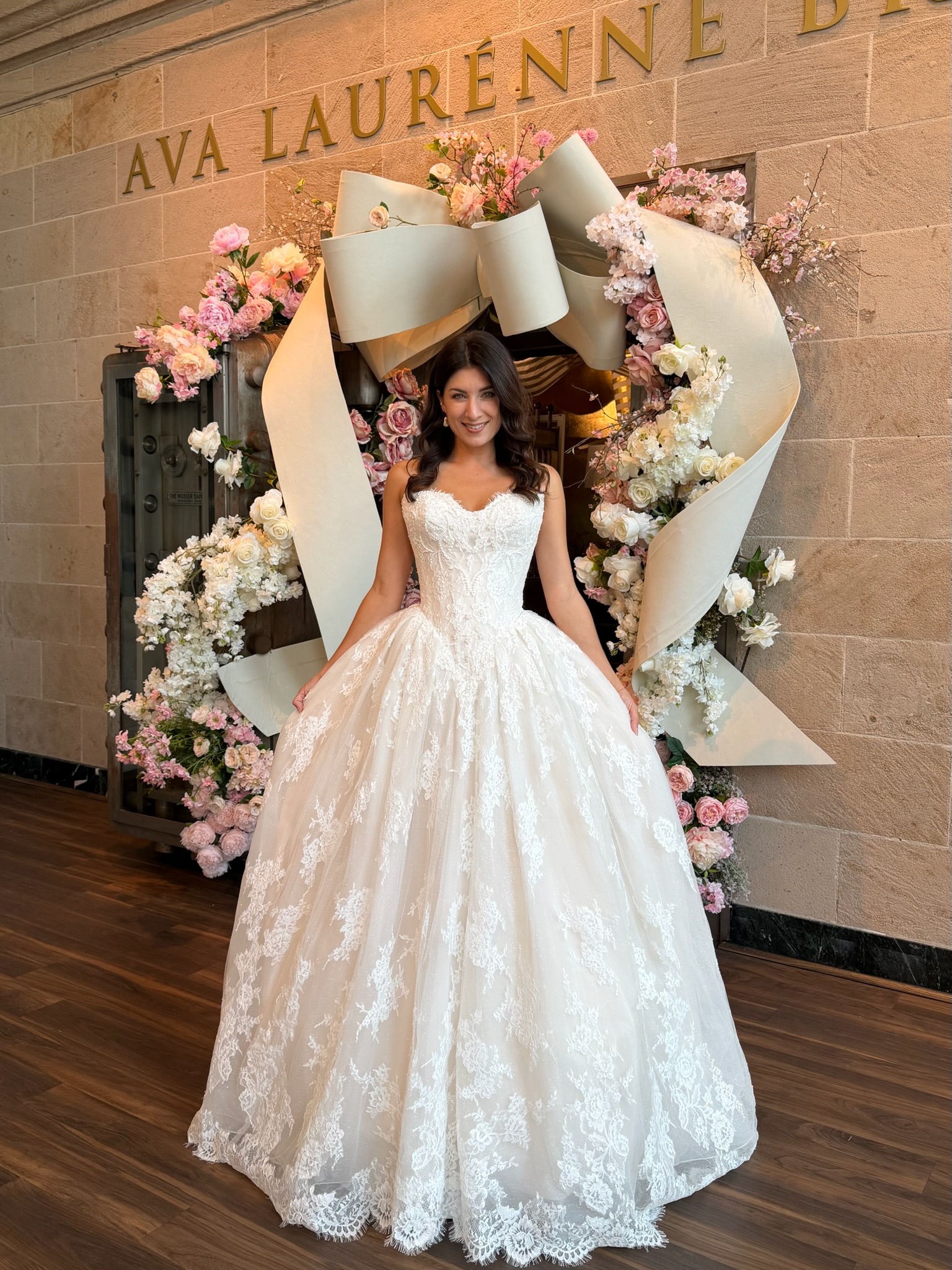 Bride trying on a romantic strapless lace wedding dress at Ava Laurènne Bride in Fredericksburg, Virginia