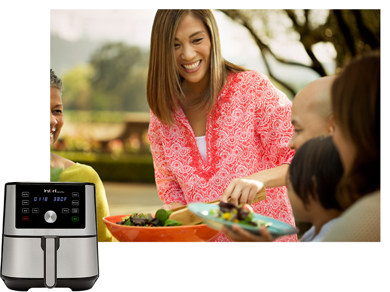 Mother serving her family salad on their outdoor patio.
