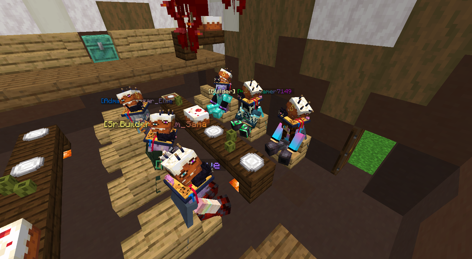 Minecraft characters with cake heads sitting around a table with birthday cakes in a wooden room.