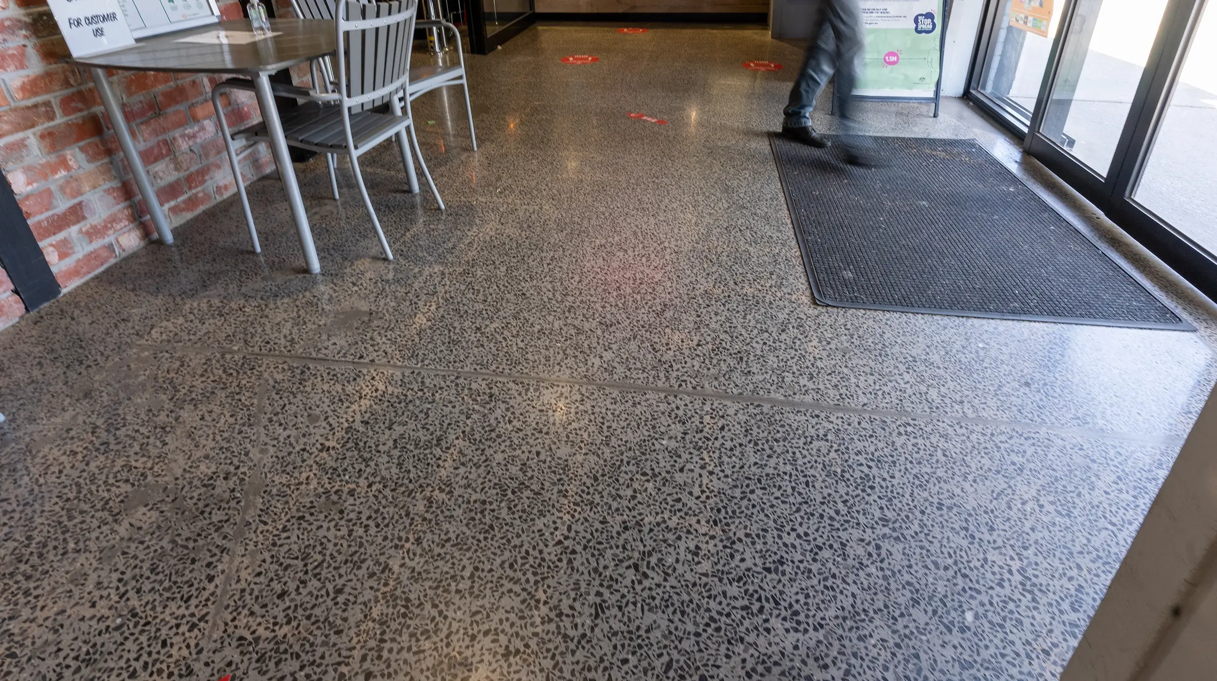 Durable polished concrete flooring at supermarket entrance with slip-resistant finish.