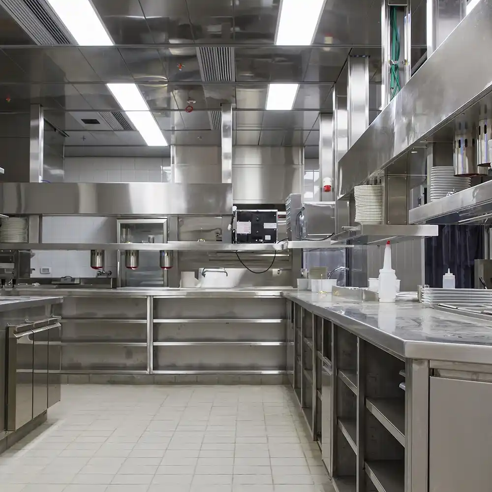 Wide-angle view of a commercial stainless steel kitchen with durable non-slip tiled flooring.