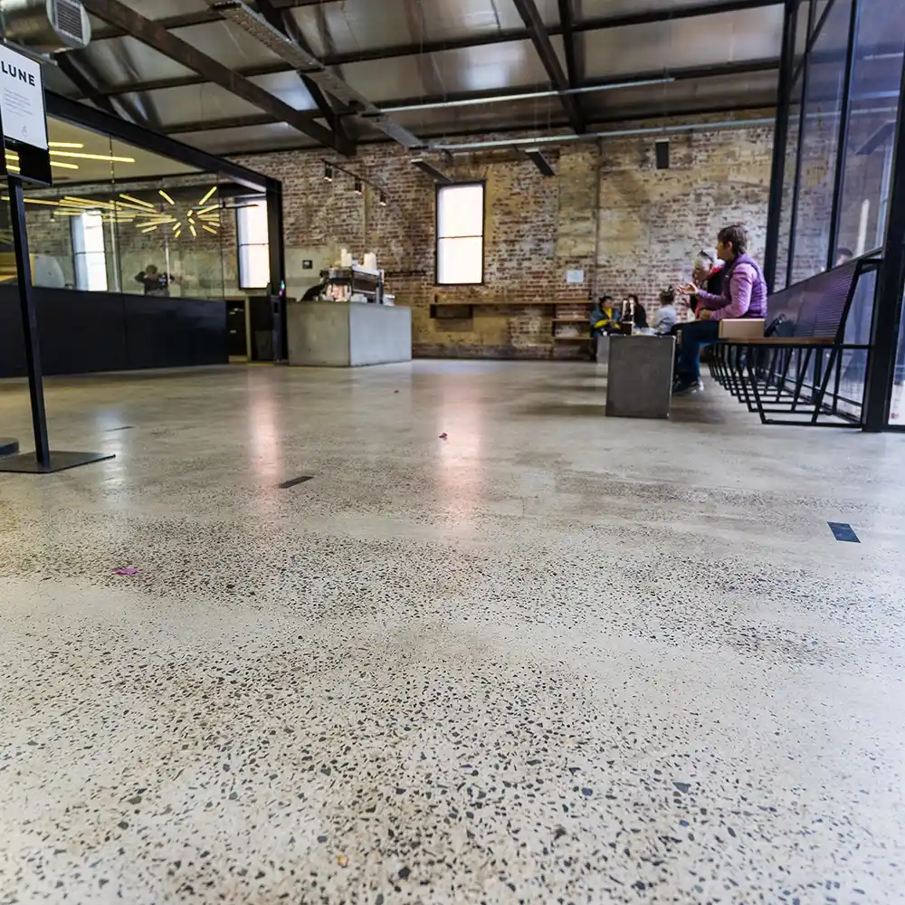  Close-up of a tiled hospitality counter and red tiled flooring in a cafe with minimalist design.