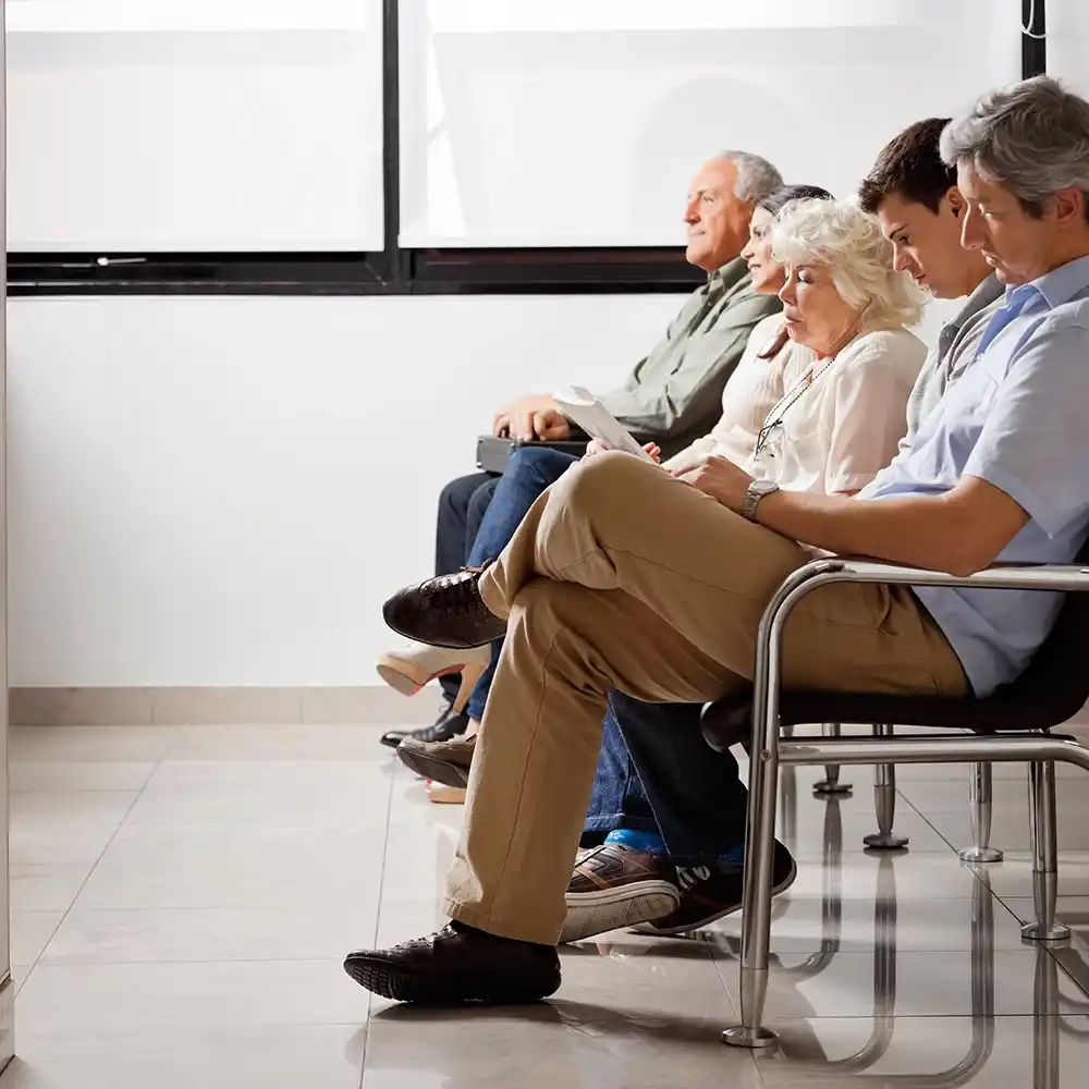 Patients seated in a hospital waiting area with hygienic, easy-to-clean flooring.
