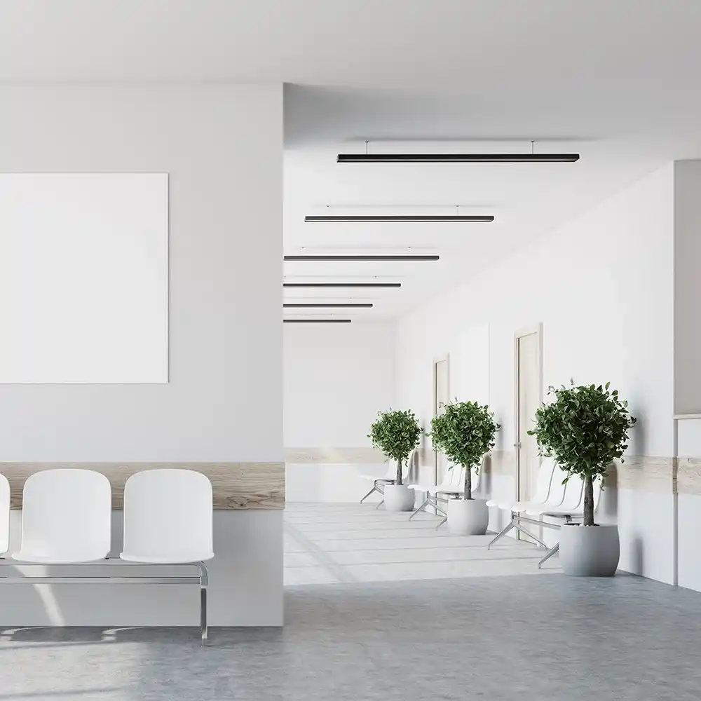 Minimalist hospital corridor with white seating and seamless epoxy flooring designed for infection control.