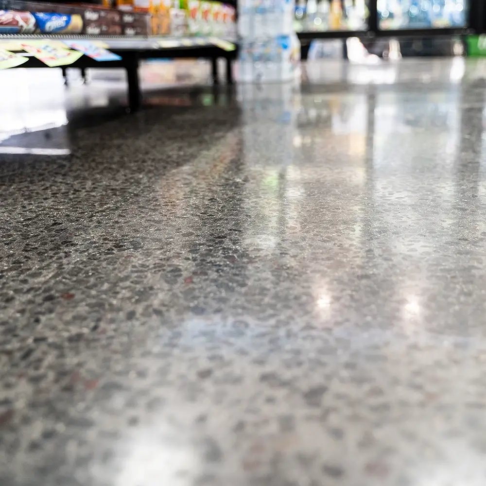 Close-up of polished concrete flooring in a shopping centre, highlighting the smooth and reflective finish.