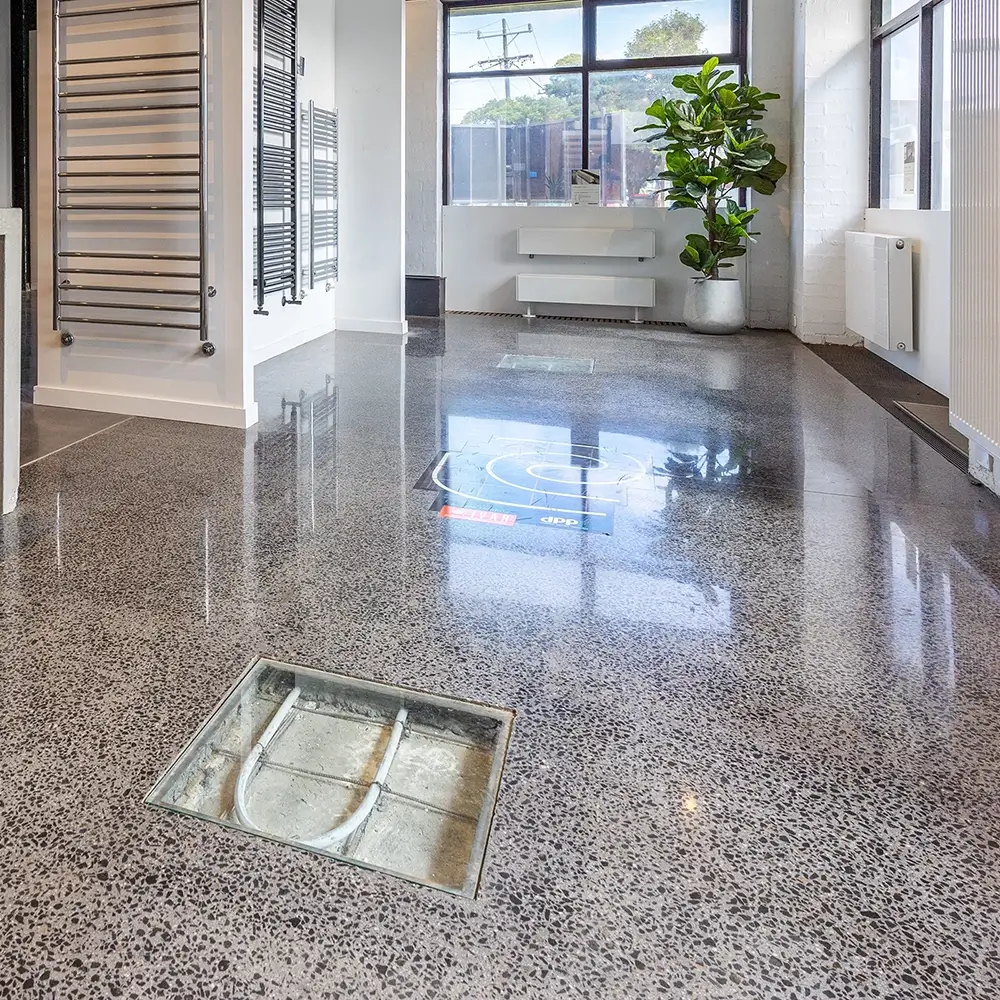 Glossy showroom floor with polished concrete finish and product displays in the background.