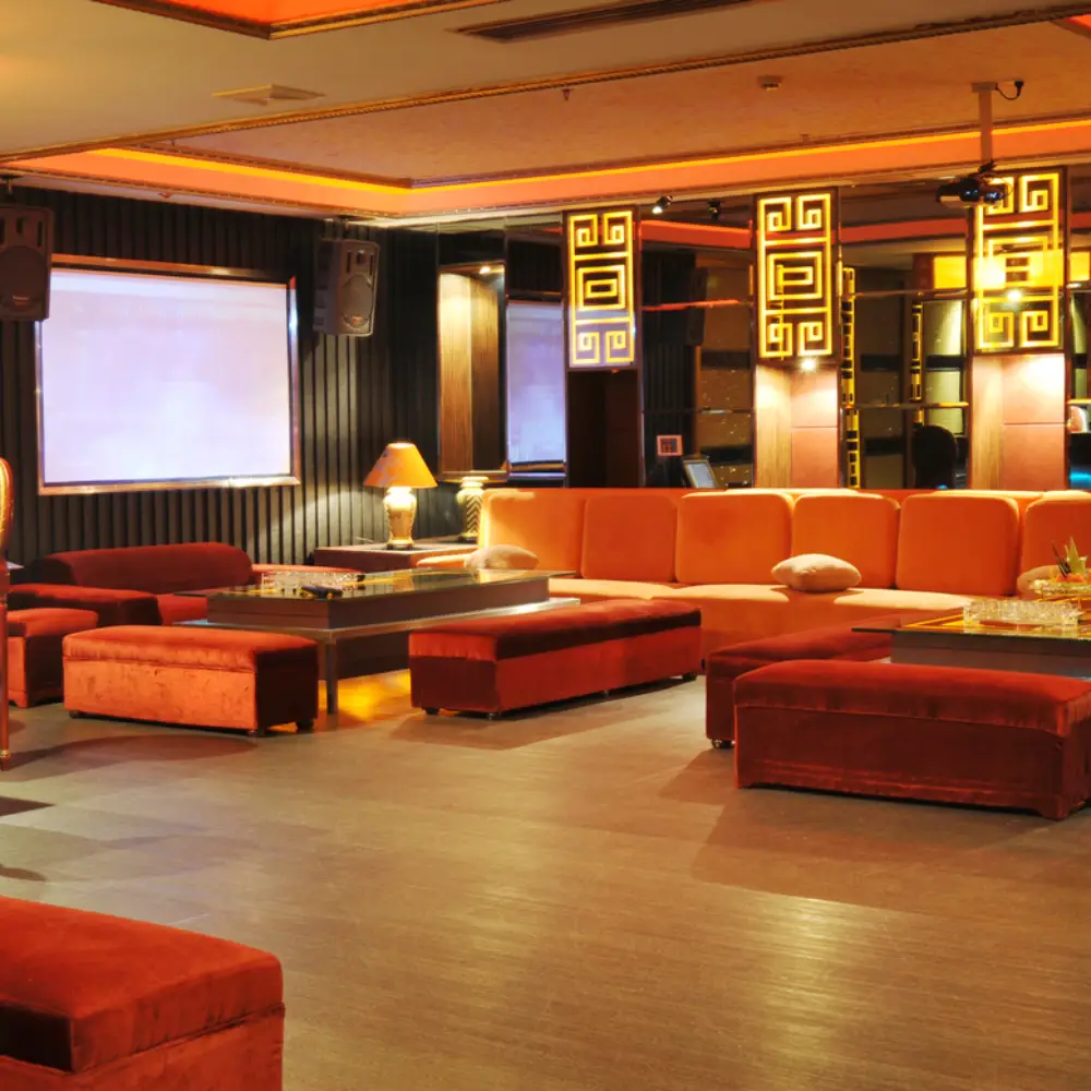 Brick-style tiled flooring in a modern open-plan pub with long wooden tables and a chef behind the bar