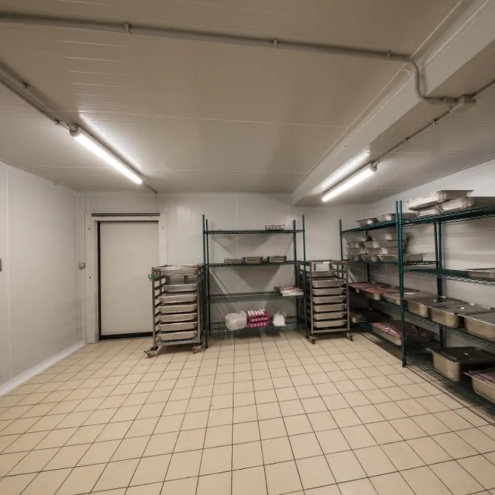 Modern commercial kitchen with stainless steel cooking equipment and slip-resistant epoxy flooring.