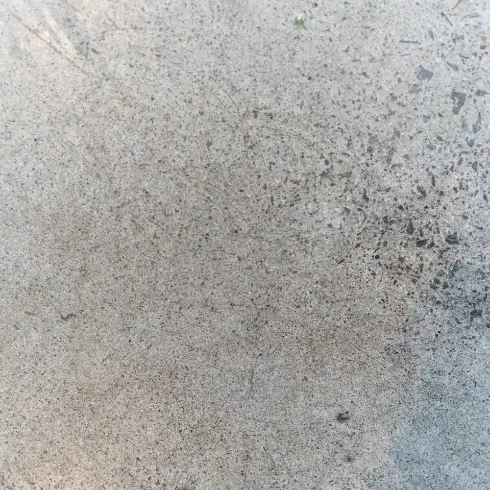 Close-up of a textured concrete floor with visible aggregate and subtle surface scratches.