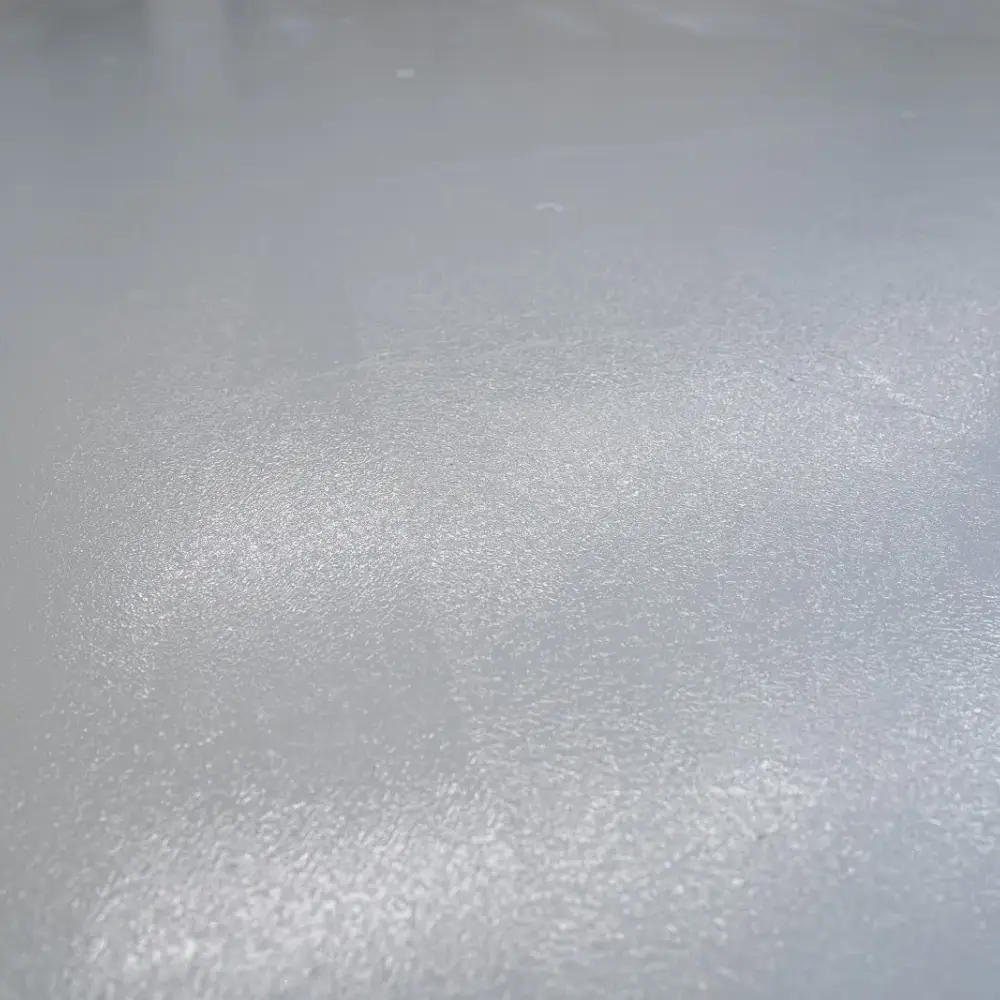 Close-up of a freshly applied epoxy-coated concrete floor with a smooth, glossy finish and subtle texture.