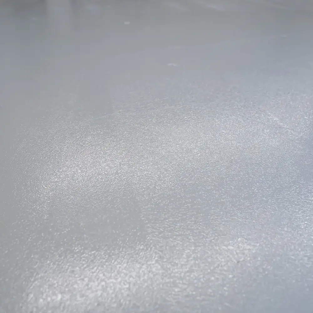 Close-up of a freshly applied epoxy-coated concrete floor with a smooth, glossy finish and subtle texture.