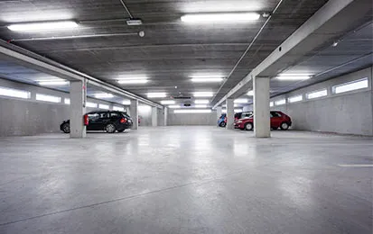 Modern showroom featuring high-gloss polished aggregate flooring, black bar stools, and underfloor heating displays.