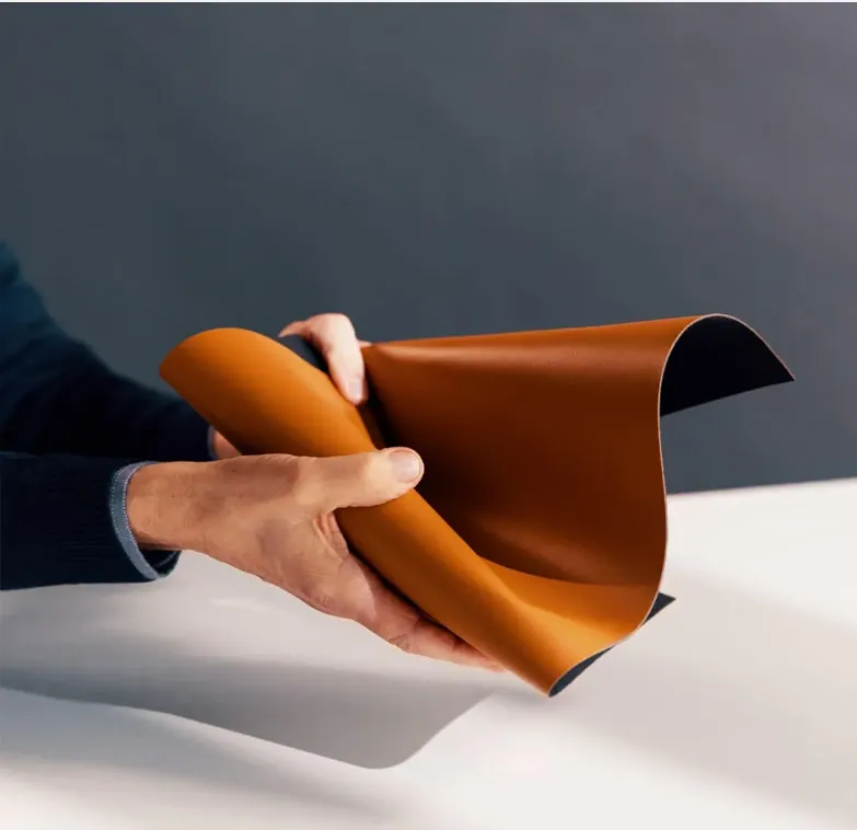 Hands flexing a sheet of Leap to show the hand of the material