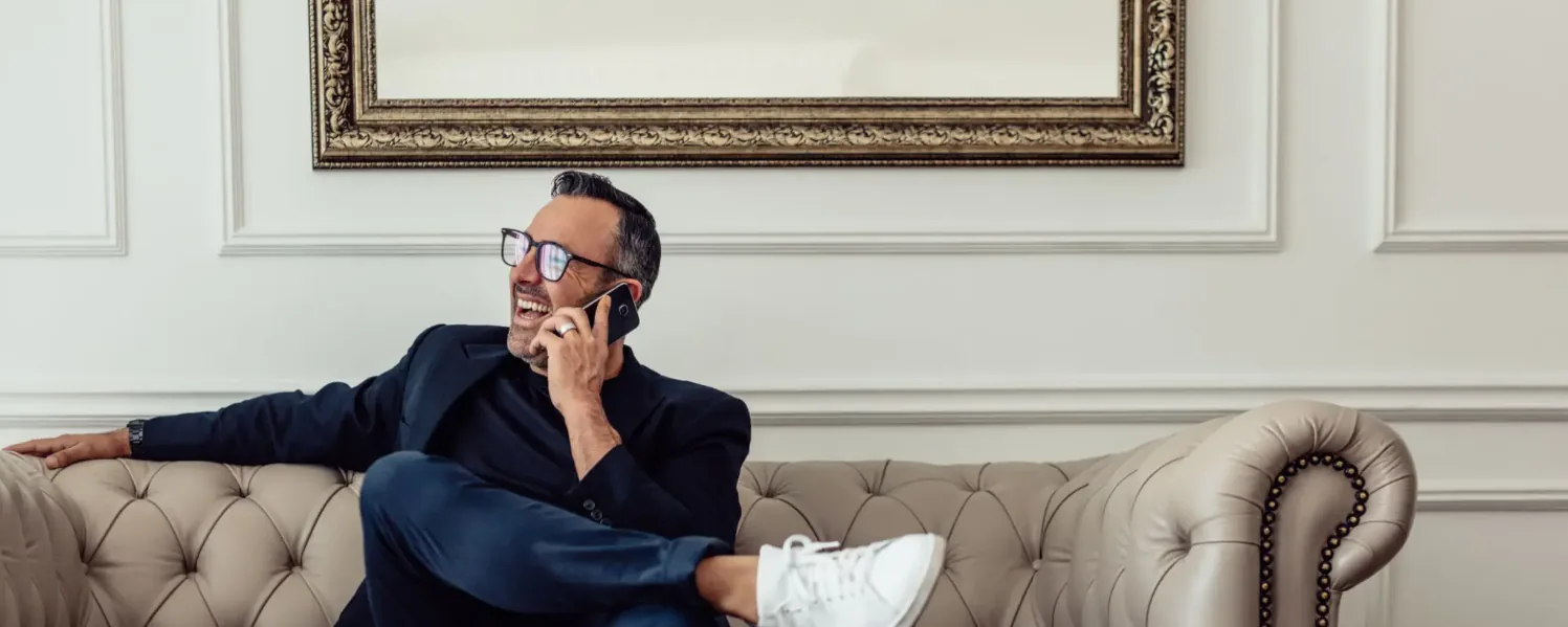 Business executive on a phone call while relaxing on a sofa
