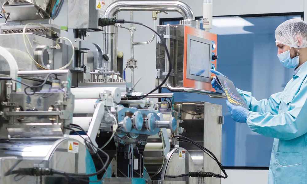 Technician in a clean room operating manufacturing equipment