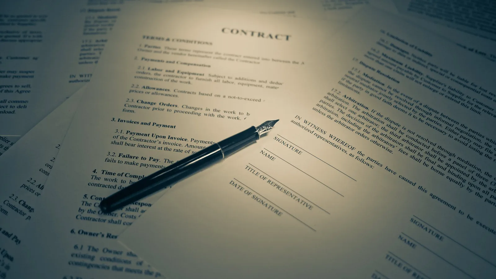Printed contract and pen on a desk
