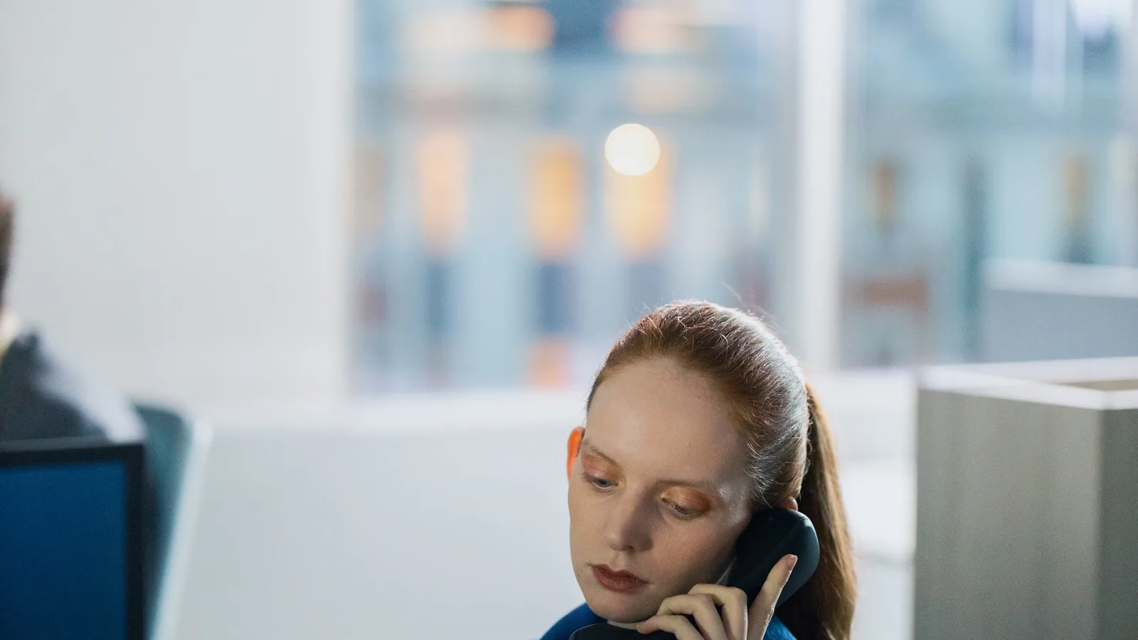 Person taking a call in an open-plan office