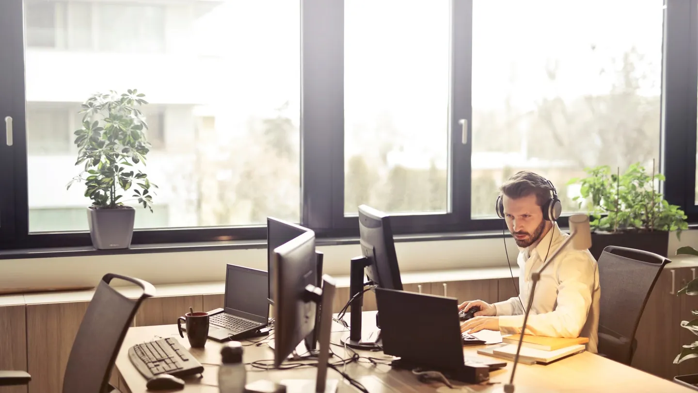 IT support specialist working at a multi-monitor desk