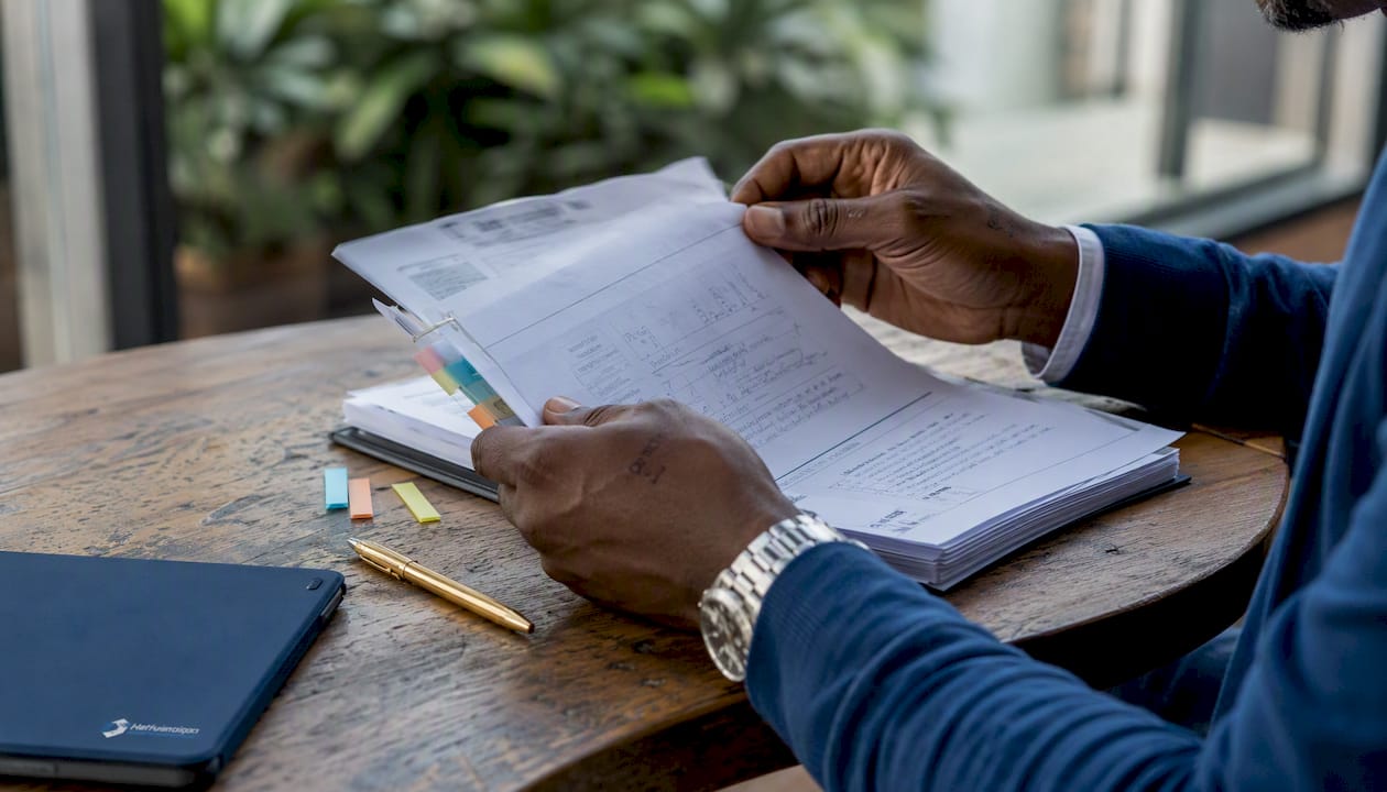 Hands reviewing detailed IT onboarding playbook
