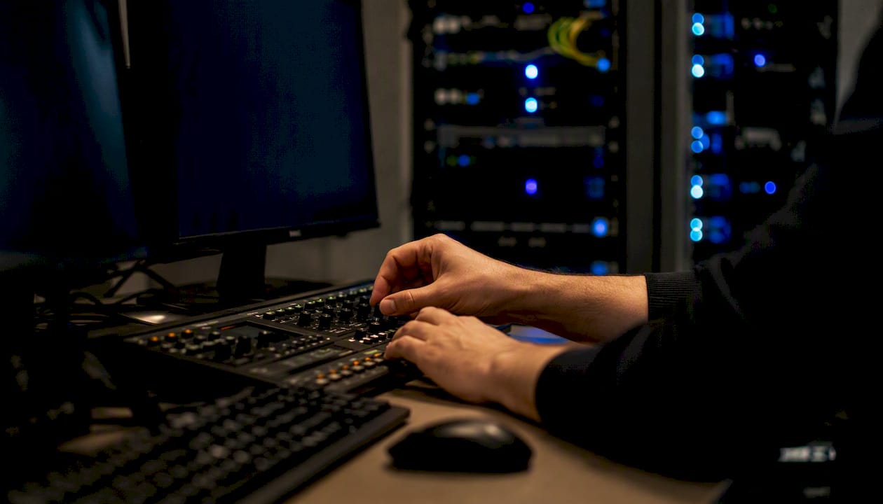 Hands tuning alerts at an IT workstation