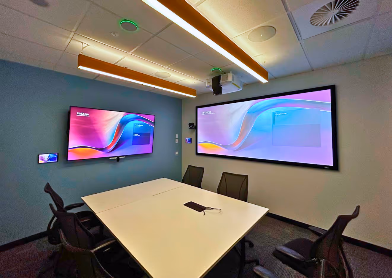 An immersive Microsoft Teams Signature Room with 21:9 Epson wide format projection displaying Microsoft Teams Front Row plus secondary LCD display, Poly AI tracking camera, Crestron Flex and control, and biamp audio.