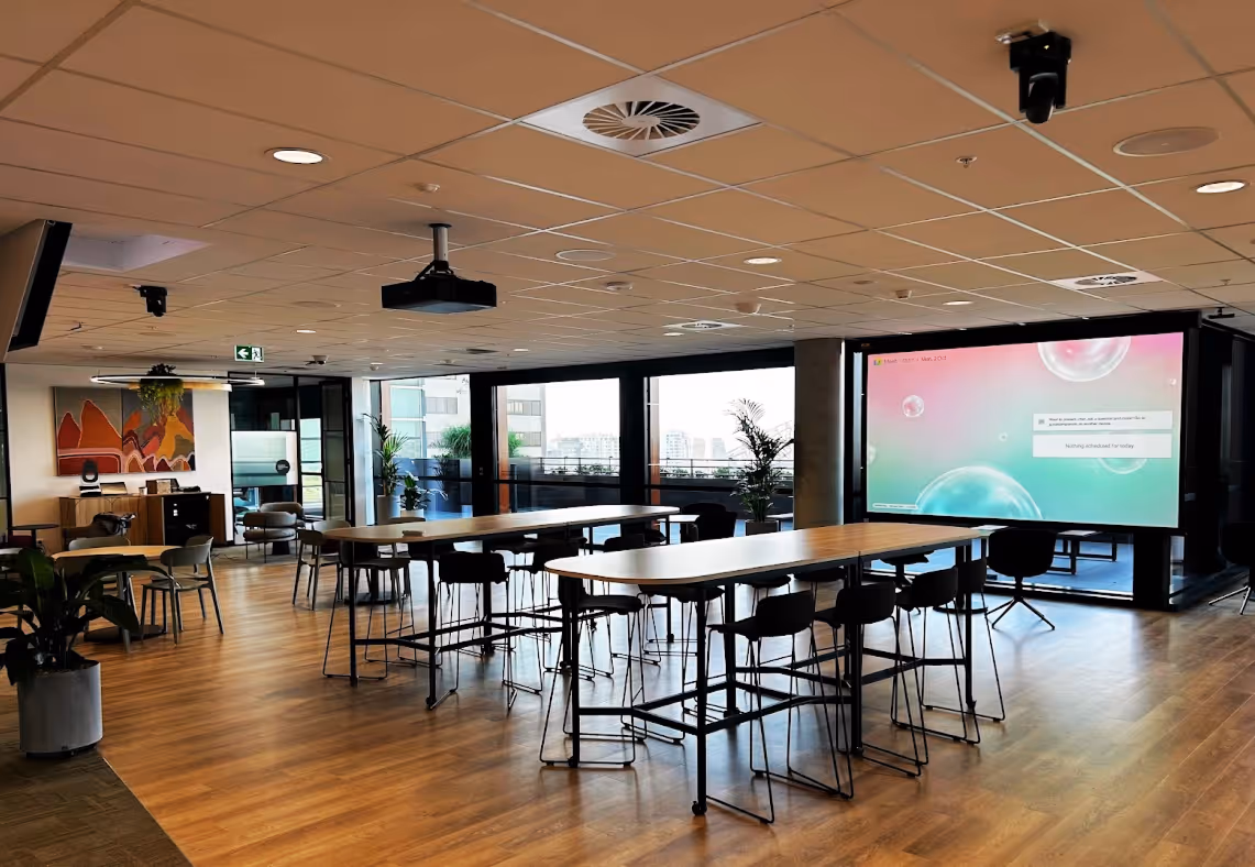 Large Google Meet Town Hall space utilising Epson projection, Q-SYS multi-camera and control system and Sennheiser audio components.