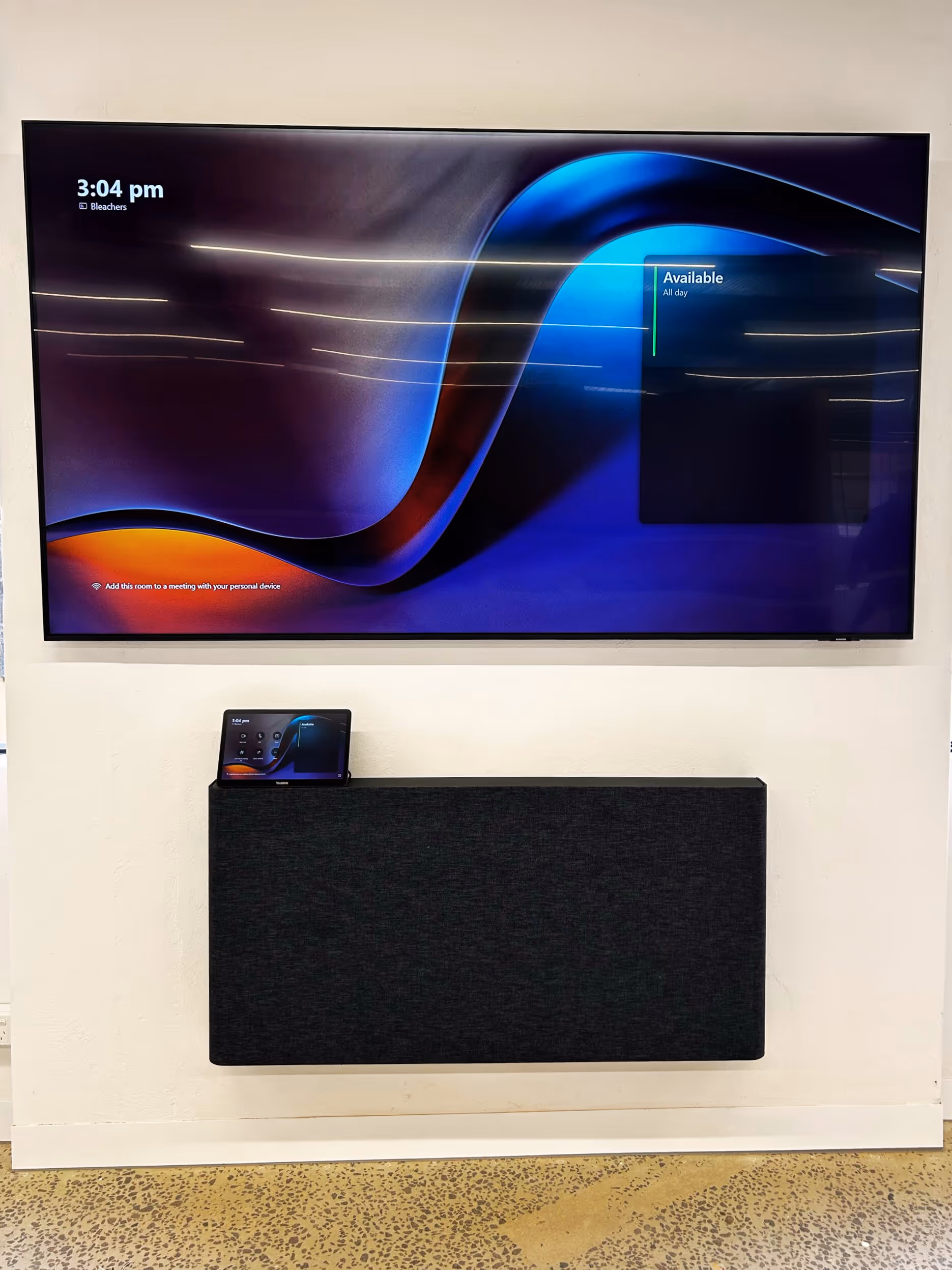 A Microsoft Teams Rooms Town Hall space with Yealink compute and touch panel, and biamp and Yamaha audio components installed on the ceiling and in the wall mounted AV credenza from Heckler.