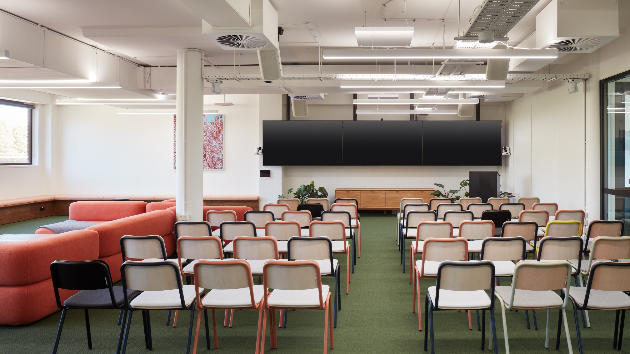 This Zoom Room, built around a Mac Mini, elevates hybrid meetings beyond standard setups. It features 3x front-facing Sony displays and a rear confidence monitor for presenter engagement with both in-room and remote participants. The system includes 5 cameras: 1x AVer CAM340+ for a wide-angle audience view, and 4x AVer PTZ310UV2s for speaker tracking across 6 zones (4 audience, 2 presenter). Custom programming enables seamless camera transitions with pre-loaded views for a smooth, broadcast-style experience. Audio clarity was vital due to room acoustics, achieved through a QSC Core 110f DSP, Lab Gruppen and QSC amplifiers, and Sennheiser TeamConnect 2 ceiling microphones. A key requirement was native Zoom UI control of zoned tracking—without extra menus. Using USB extenders and Wyrestorm NHD500 AVoIP encoders, each camera appeared as an individual source within Zoom, allowing intuitive camera switching and maintaining a high-quality, inclusive experience. Inavate APAC Project Winner for 2025.