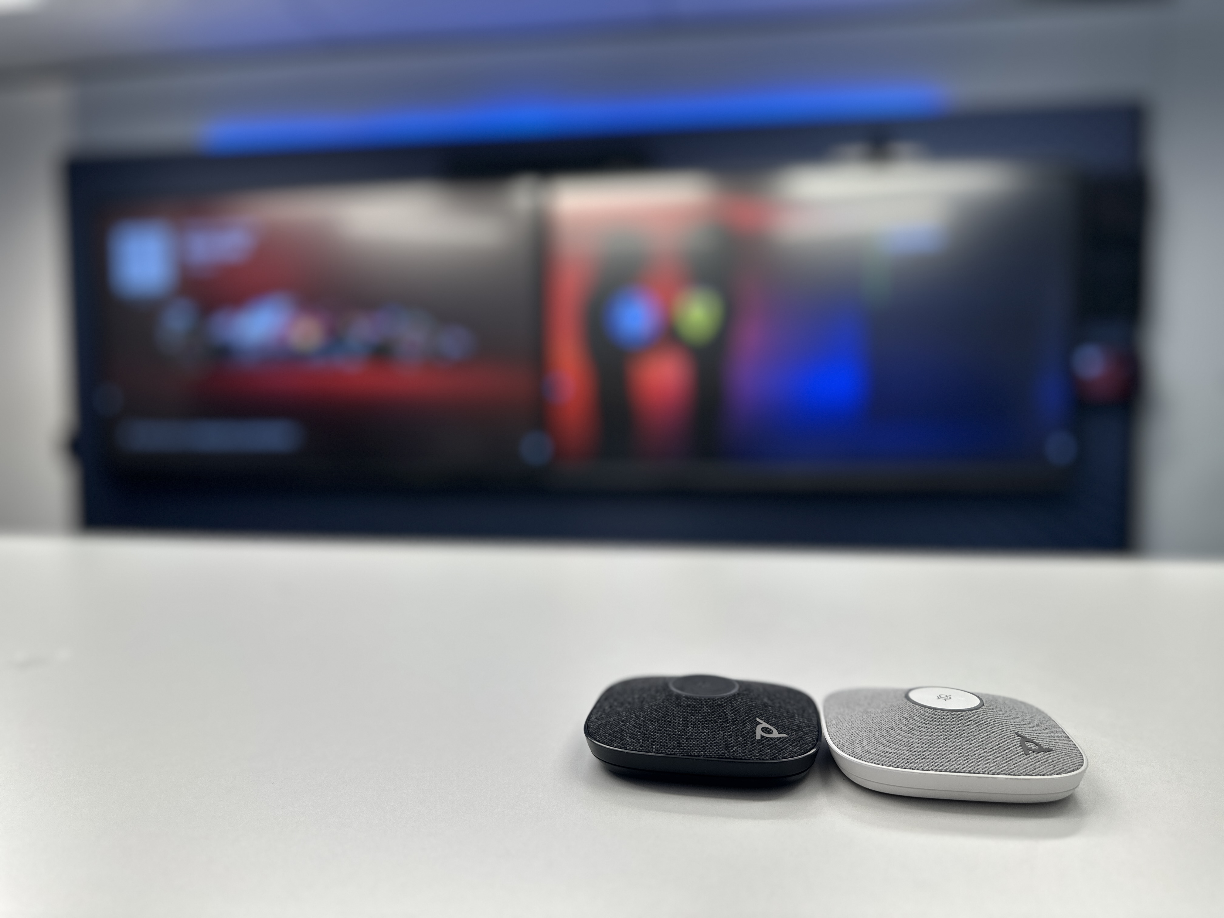 Large Microsoft Teams Boardroom equipped with HP Poly X72 video bar, Poly Studio E70, HP Poly Studio A2 Table Mic (in black and white), and 2x 85" interactive displays