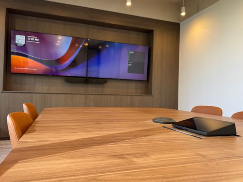 Large Microsoft Teams boardroom equipped with Logitech Rally Bar, Logitech Tap IP, Logitech Mic Pod, and Logitech Extend
