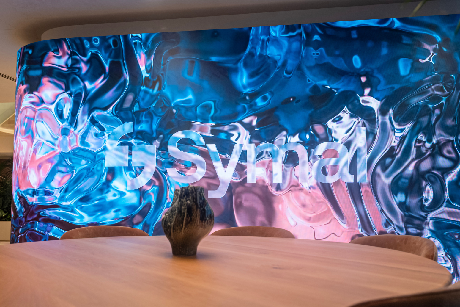 Custom Absen curved 8.25m x 2.5m K1.8 V3 LED wall at client's reception area. Inavate APAC 2026 Corporate Project of the Year Finalist with Symal.