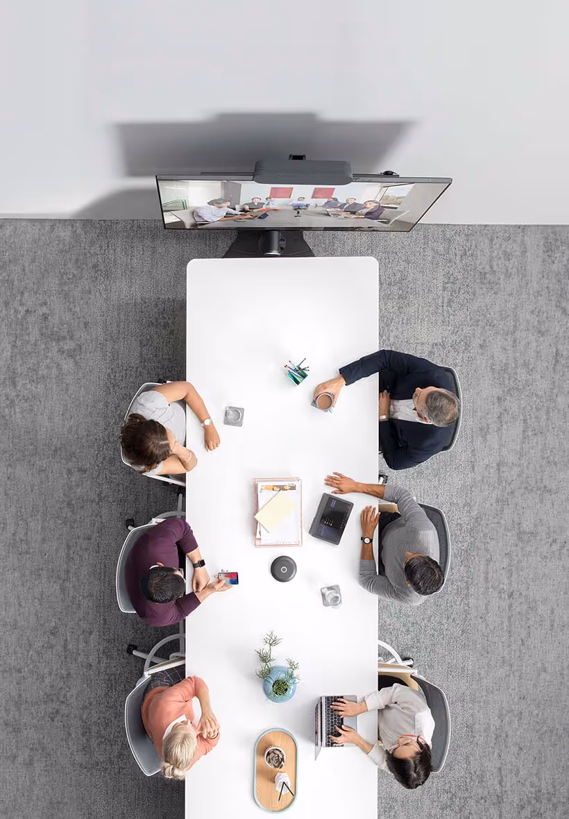 Overhead view of office meeting using Microsoft Teams Rooms and devices
