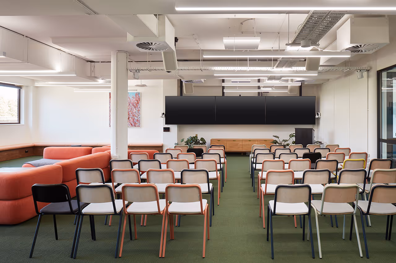 Large meeting and training space with wall-mounted displays and cameras at Canva offices