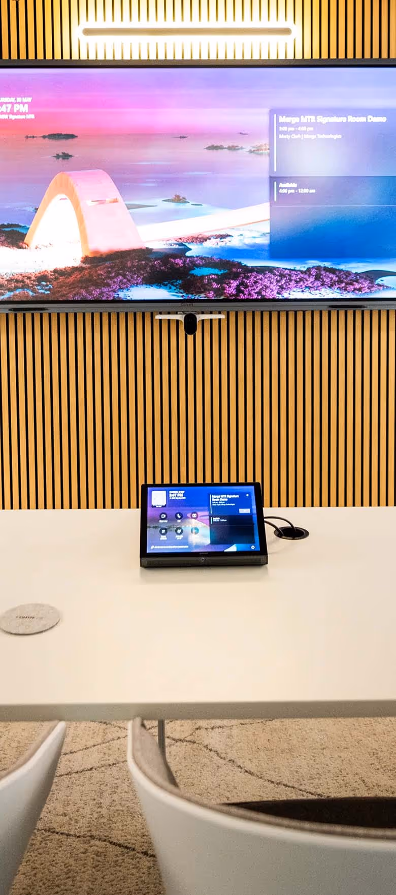 Microsoft Teams Room with wide-format display on wall in front of modern curved meeting table