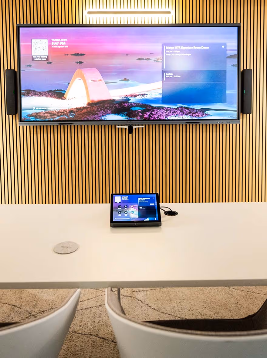 Microsoft Teams Room with wide-format display on wall in front of modern curved meeting table