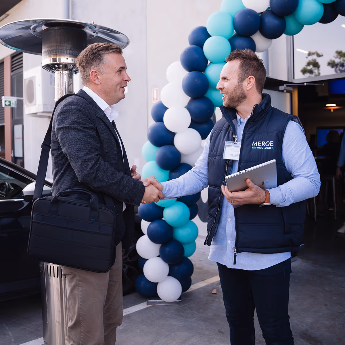 Merge Technologies director Marty Clark shaking hands with a client