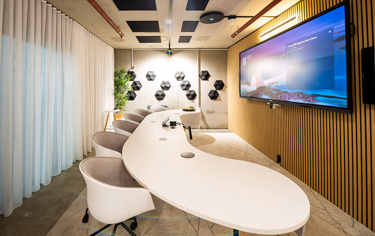 High-tech Microsoft Teams meeting room with ultra-wide screen, ceiling-mounted speakers and microphone, designed and installed by Merge Technologies