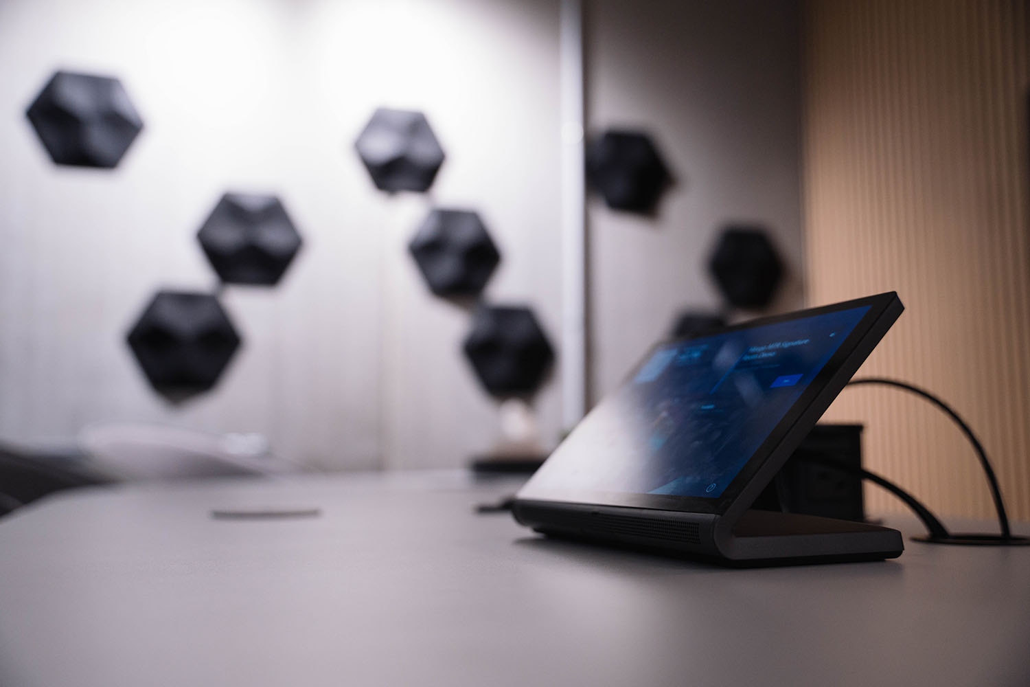 Close up of Crestron tabletop touch screen meeting control device on a desk in a modern office meeting room