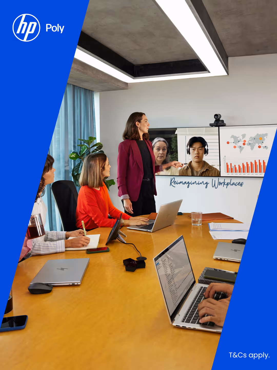 A business meeting with four people at a conference table using laptops and video conferencing with two remote participants displayed on a screen showing charts and a world map.