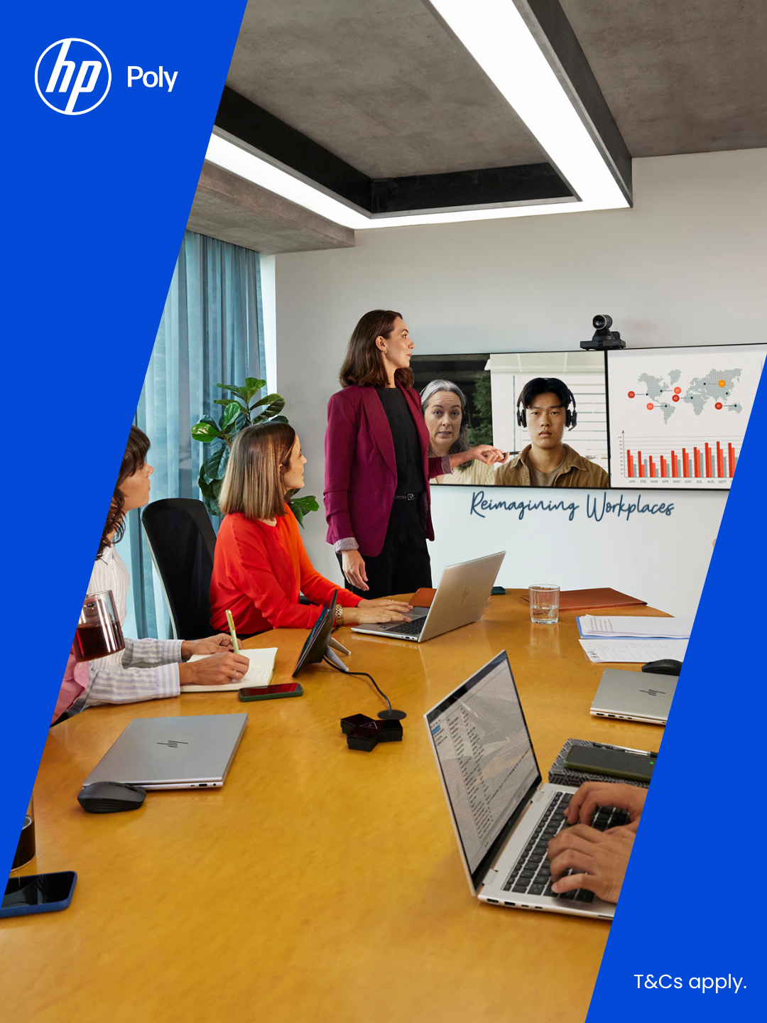 A business meeting with four people at a conference table using laptops and video conferencing with two remote participants displayed on a screen showing charts and a world map.