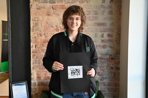 Student holding up a lino print