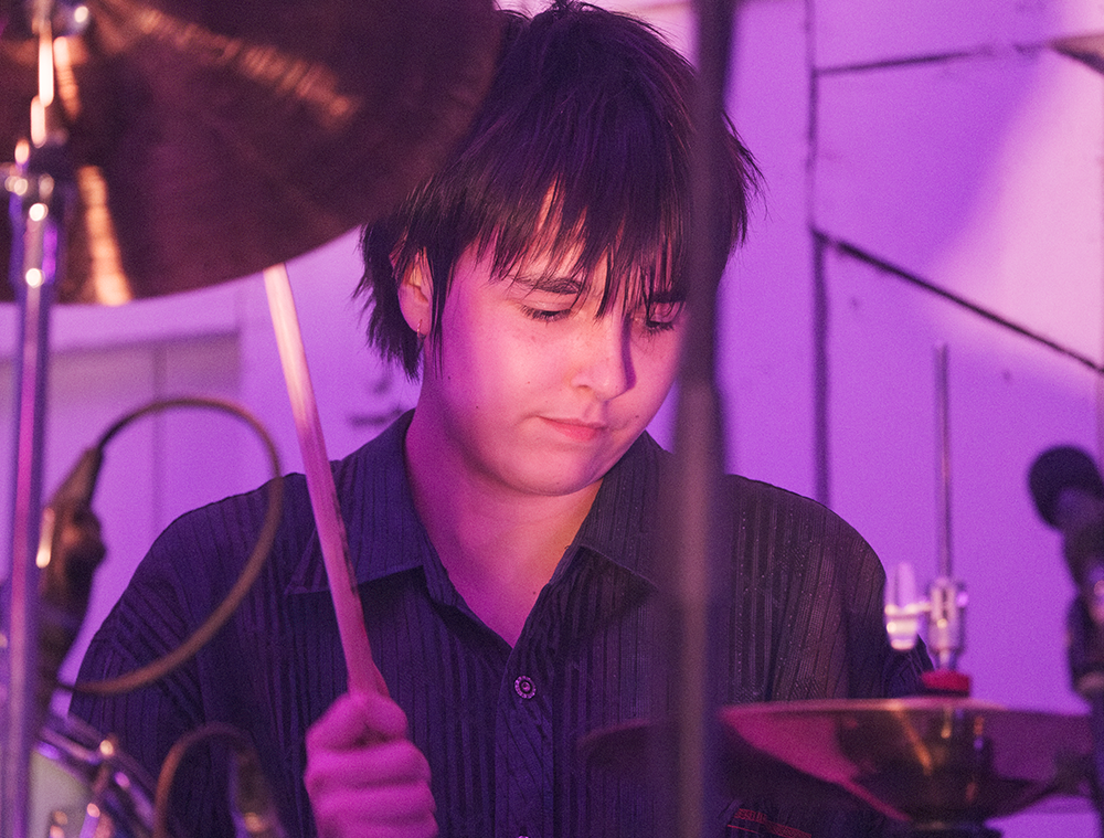 A band performing on stage at an indoor concert