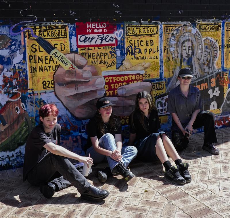 Student painting a mural on a wall