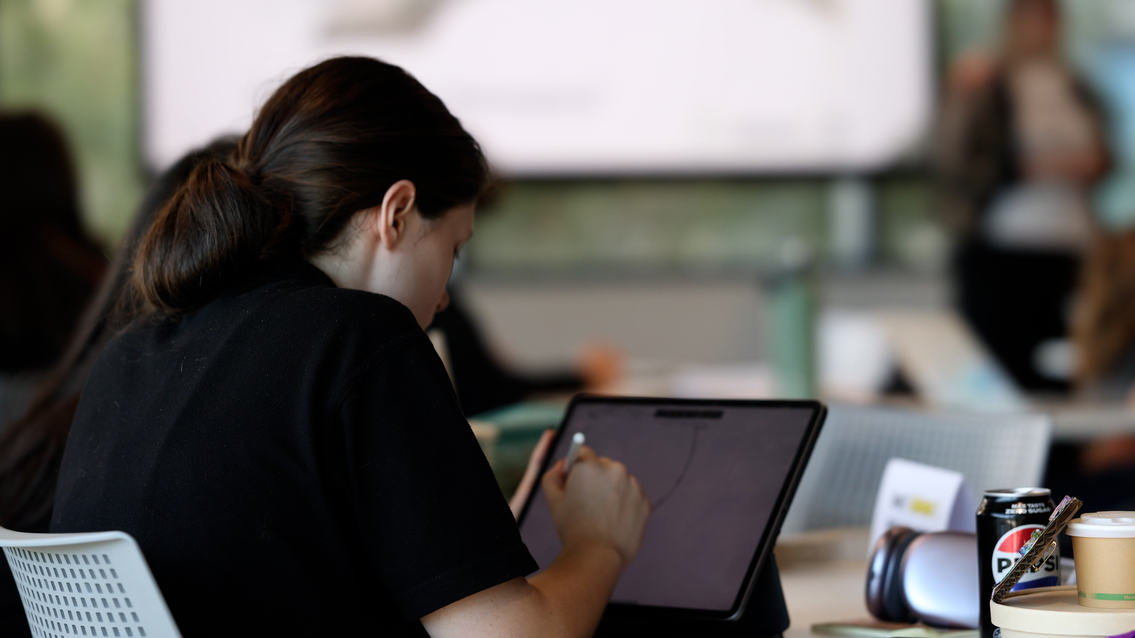 Student drawing with a stylus on a laptop