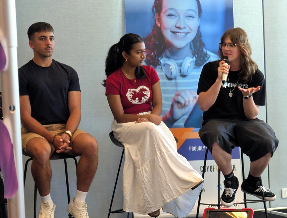 Three teenagers sitting on a panel