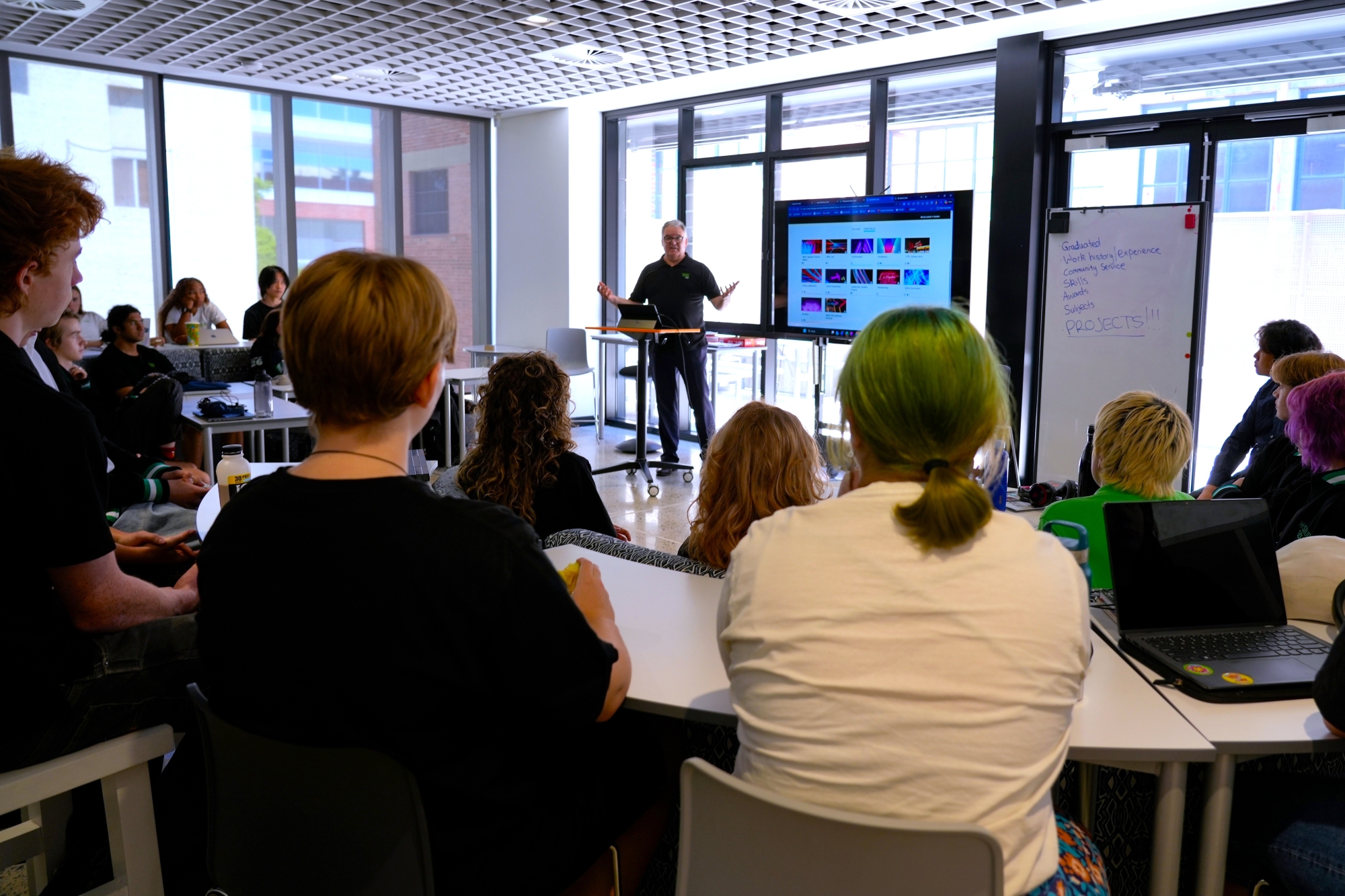 Teacher presenting e-portfolio PowerPoint to a room full of students