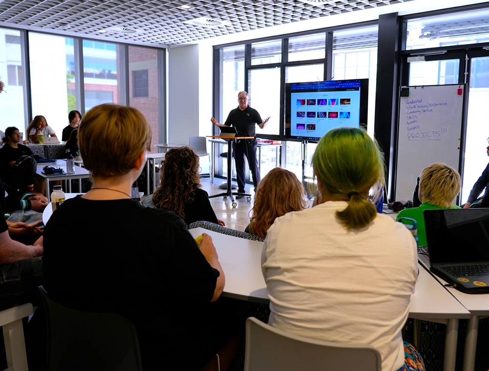Teacher presenting e-portfolio PowerPoint to a room full of students