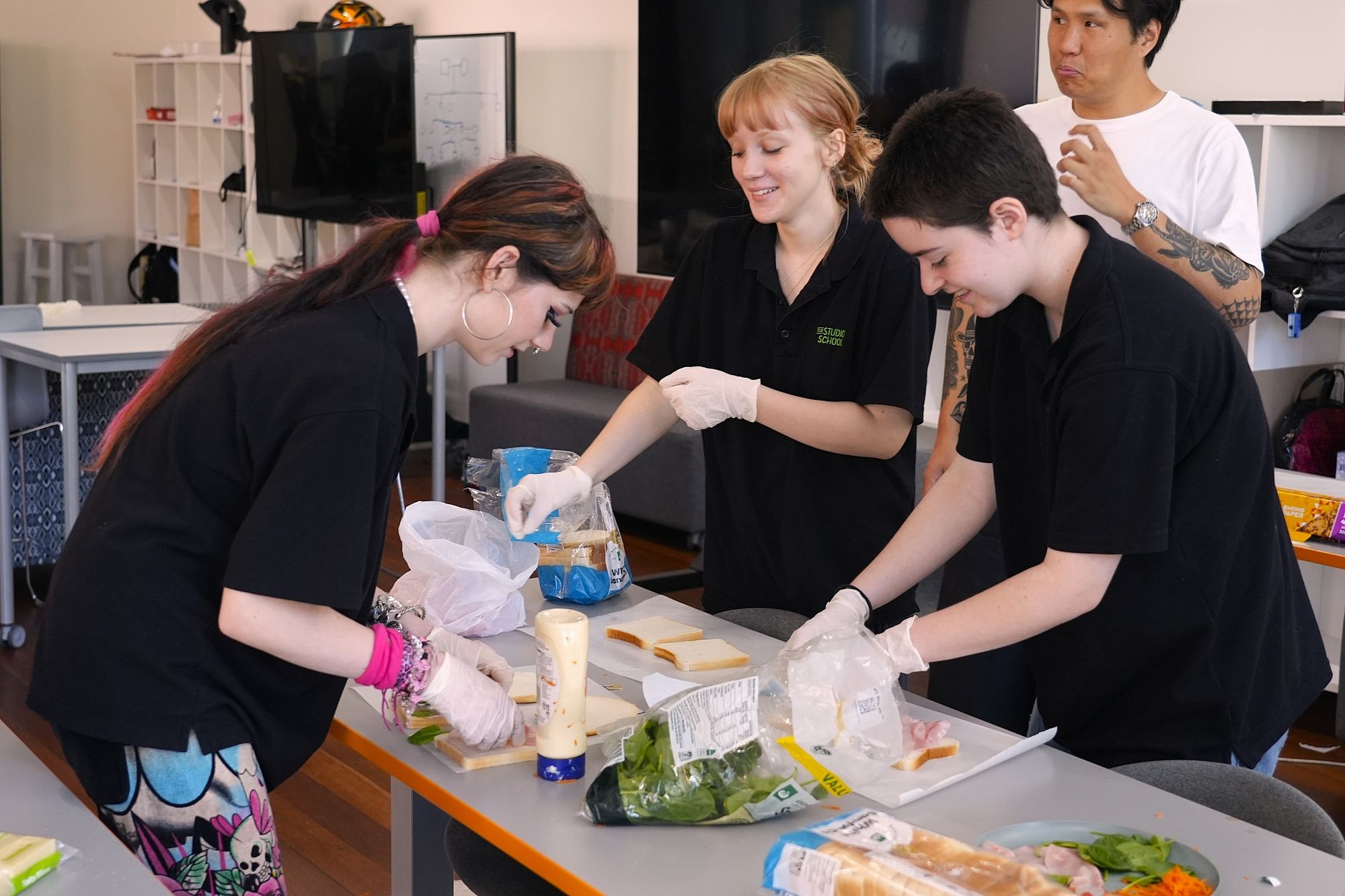 Group of three students preparing sandwiches