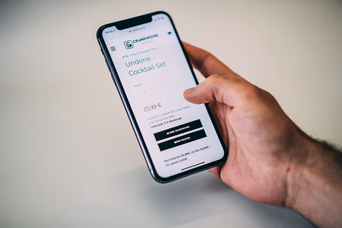 Ein Mann legt beim Online-Shopping am Handy einen Artikel in den Warenkorb.