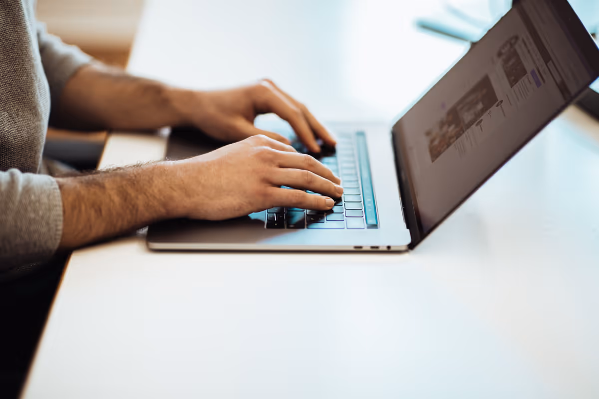 Ein Agentur Mitarbeiter arbeitet an einem Macbook. 